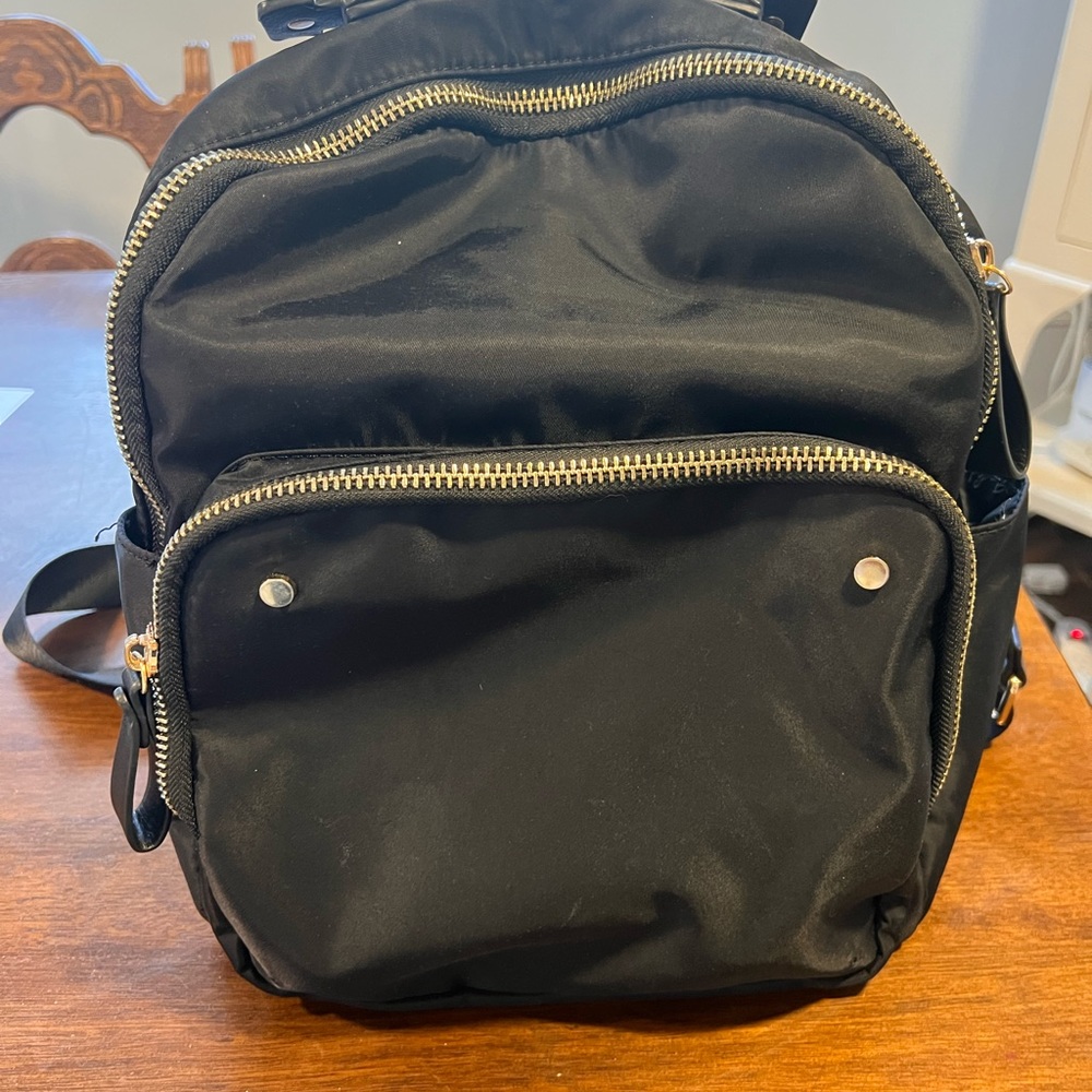 Black MMS backpack with gold accents and interior pockets
